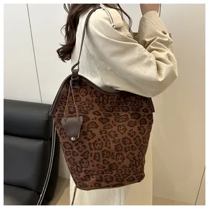 Side view of leopard print tote bag with brown leather straps worn by a model