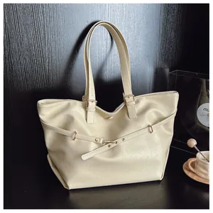 Dettaglio della borsa tote off-white in ecopelle con cinturini decorativi e fibbia d'oro