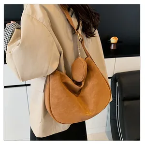 Detail of caramel brown suede crossbody bag with matching circular coin purse attachment