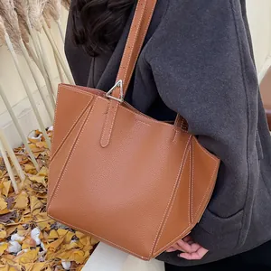 Brown lychee leather tote bag with white contrast stitching and silver metal hardware