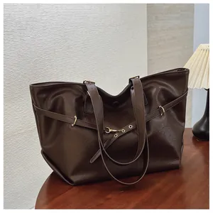 Dettaglio borsa shopper marrone scuro con trama in pelle e fibbie in metallo dorato