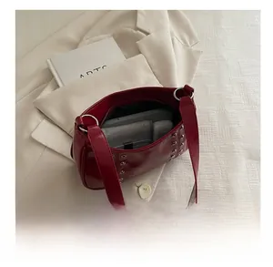 Interior view of red glossy underarm bag showing space for phone and wallet with rivets