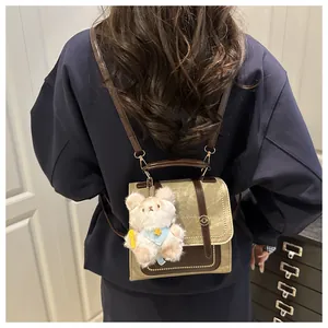 Sac à dos vintage en cuir marron avec bretelles réglables et breloque ours sur modèle