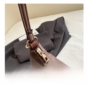 Detailed macro view of dark brown leather bag with golden zipper and metal D-ring hardware