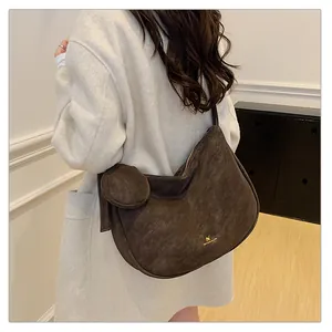 Detail of dark brown faux suede hobo bag with zip closure and matching round pouch