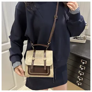 Détail d'un petit sac à main rétro en cuir PU texturé avec des accents de rivets dorés