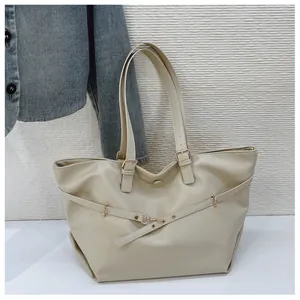 Dettaglio della borsa tote beige in finta pelle con fibbia dorata e texture fine
