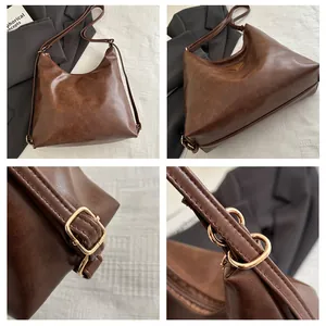 Detail view of large dark brown leather tote with metal triangle logo and adjustable strap