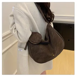 Detail of a large vintage brown hobo bag in suede with a matching mini coin purse