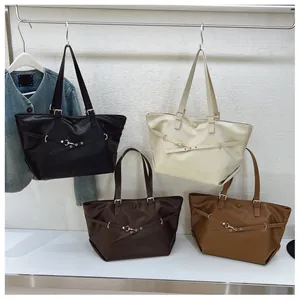 Dettaglio di quattro grandi borse tote vintage in vari colori con fibbie metalliche di lusso