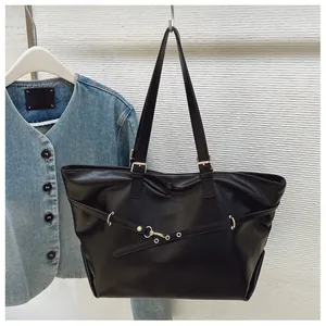 Dettaglio della grande borsa tote nera con fibbia in metallo dorato e cinturini decorativi