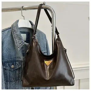 Close-up of deep brown vintage faux leather tote featuring a golden triangle emblem detail