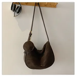 Detail of dark brown suede hobo bag with matching round coin purse on wood hook