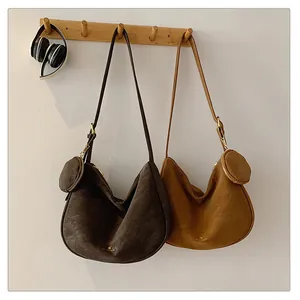 Detail of minimalist suede hobo bags in dark coffee and caramel with coin purses