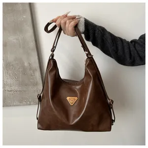 Detail of coffee brown retro tote bag featuring gold hardware and a polished PU leather texture
