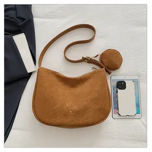Detail of brown faux suede half-moon crossbody bag with detachable round coin purse