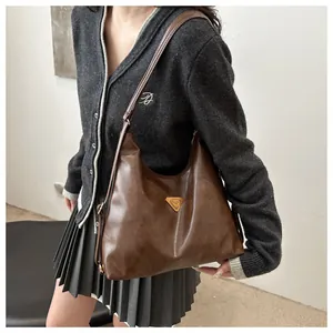 Close-up of vintage dark brown faux leather tote with iconic triangle metal hardware