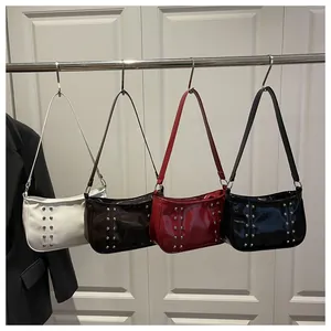 Detail shot of vintage leather underarm bags with studs in white, brown, red, and black
