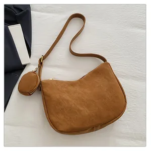 Detail view of brown suede crescent bag with matching round coin purse and gold hardware