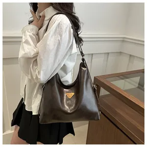 Detail view of the large dark brown leather tote bag styled with an elegant commute outfit