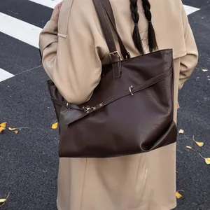 Grande borsa tote vintage in ecopelle marrone con dettagli dorati in strada