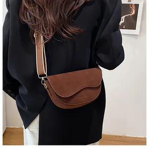Detail der dunkelbraunen matten Satteltasche mit Wellenkante und breitem Webgurt