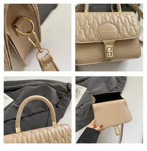 Detail view of beige quilted handbag with gold hardware and fashion lettering