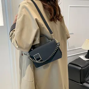 Bolso bandolera cuadrado de cuero negro con hebilla dorada y correa de cadena tejida