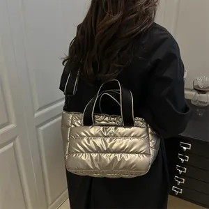 Gesteppte Metallic-Champagner Puffer-Tasche mit schwarzen Riemen für den Winter-Look