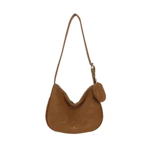 Brown faux suede hobo bag with adjustable strap and matching round coin purse on white background
