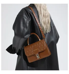 Brown quilted PU leather bag with Fashion logo and metal buckle worn by a model