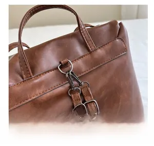 Macro view of gunmetal matte hardware hook and textured leather strap on vintage tote bag