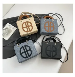 Dettaglio di borse tote vintage in pelle opaca in quattro colori con loghi circolari