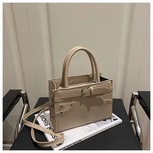 Detail view of cream leather handbag with silver rivets and decorative buckle straps