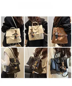 Detail of vintage matte leather backpack featuring a metal twist lock and rabbit charm