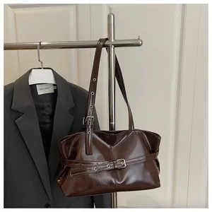 Detail van de donkerbruine vintage schoudertas met glanzende afwerking en metalen ogen