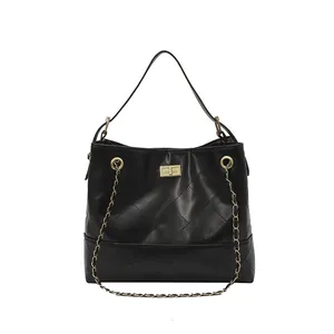 Borsa tote trapuntata nera classica con catena dorata e manico in pelle su sfondo bianco