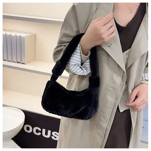 Gros plan du sac bandoulière en peluche noire porté avec un trench-coat kaki chic