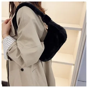 Détail d'un sac sous les aisselles en peluche noire associé à un trench-coat élégant