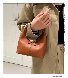 Detalle del bolso hobo de media luna marrón caramelo con costuras y cremallera doble