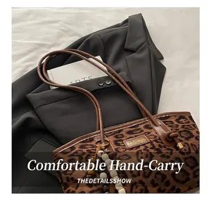 Detalle del bolso tote de ante con estampado de leopardo y colgante de cuentas