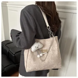 Bolso tote beige con motivos florales, cadenas plateadas y colgante de nube suave