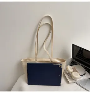 Grand sac cabas en similicuir crème montrant la capacité pour ordinateur et accessoires