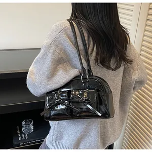 Glossy black patent leather shoulder bag with chic bow accents and dual slim straps