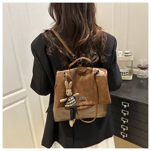 Detail of vintage brown leather tote bag with silver twist lock and bunny charm