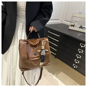 Close-up of vintage brown tote bag with metal twist lock and cute bunny pendant charm