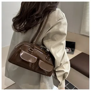 Close-up of retro brown PU leather shoulder bag with double pockets on female model