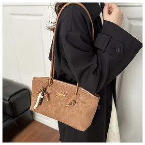 Bolso tote de ante marrón con letras FASHION y colgante de cuentas en modelo