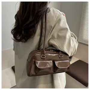 Detail of a dark brown glossy faux leather shoulder bag with double front flap pockets