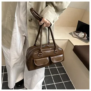 Detail of dark brown faux leather bag with glossy finish and silver double zipper
